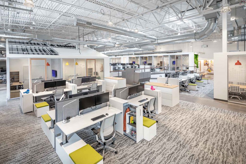 Open office floor plan showcasing cubicles and meeting spaces with exposed ceilings and duct work.