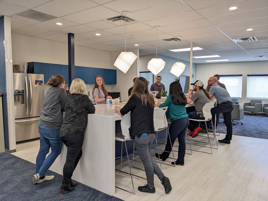 Team gathering around the kitchen island at the 360 Engineering office.