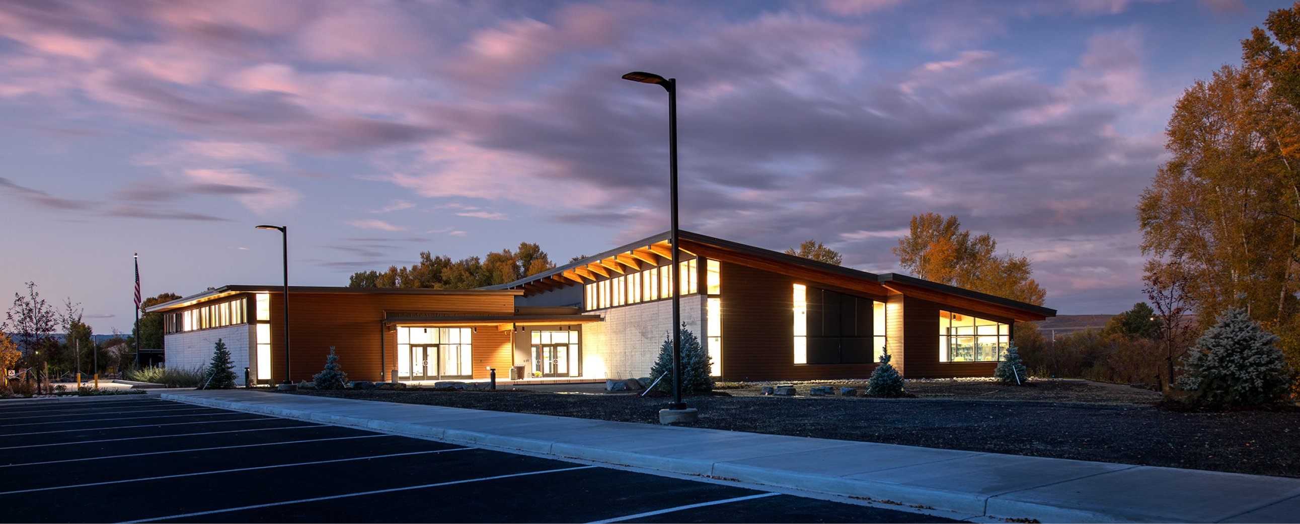 Gunnison County, Colorado Library lit building at twilight with light cloud cover.