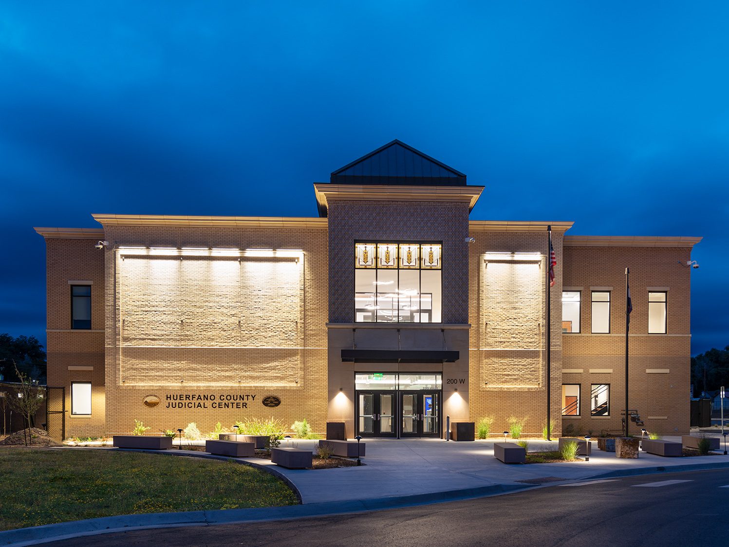 Exterior view of Huerfano County Courthouse in Walsenburg, Colorado lite up at twilight.